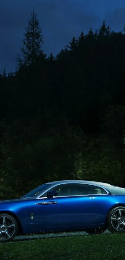 Elegant blue car parked in a dim forest at night.