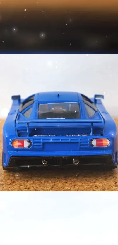 Sleek blue model car on textured surface wallpaper.