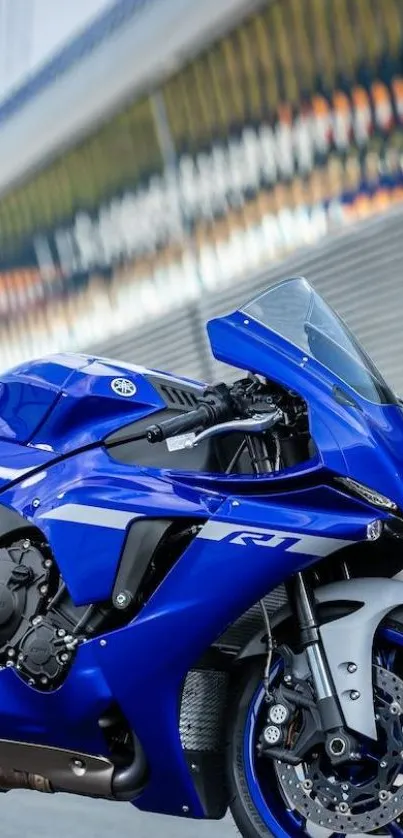 Blue sports motorcycle with urban backdrop.