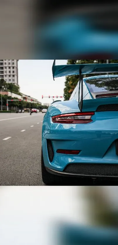 Sleek blue sports car on urban road background.