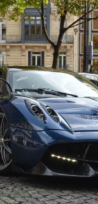 A sleek blue sports car parked on a cobblestone street with urban buildings in the background.