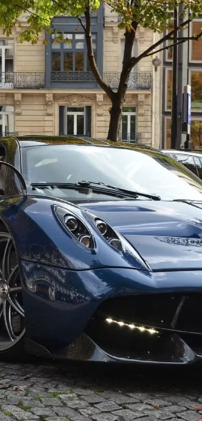 Sleek dark blue sports car parked on a cobblestone street.