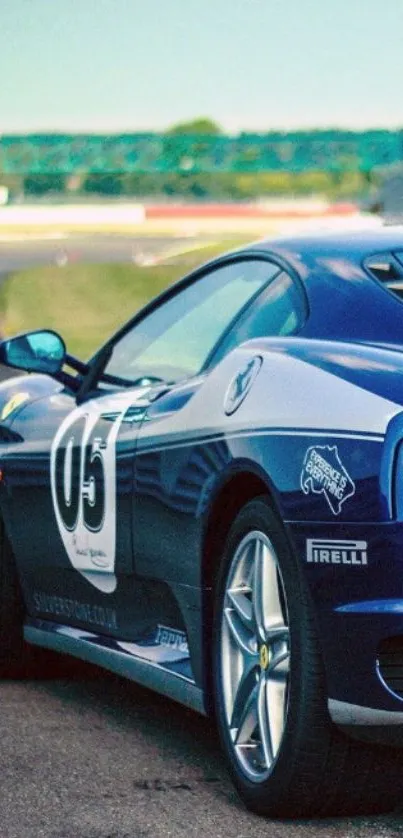 Sleek blue sports car parked on track.