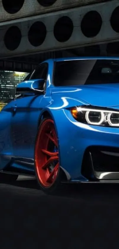 Sleek blue sports car with red wheels at night.