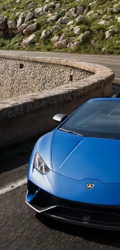 Blue sports car driving on a winding coastal road.