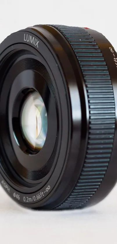 Close-up of a sleek camera lens against a light background.