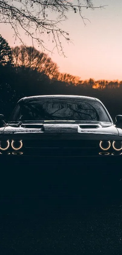 Car silhouette at sunset with glowing headlights in scenic wallpaper.