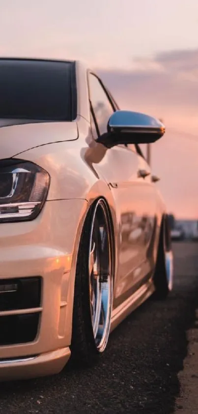 Sleek car reflecting sunset hues on an open road.