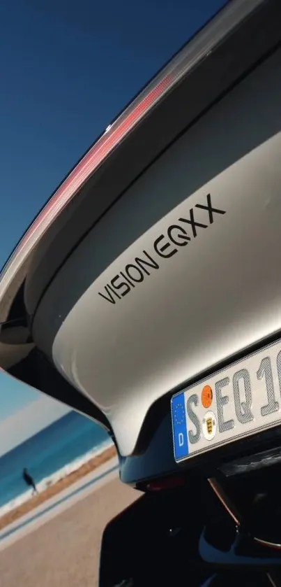 Luxury car parked beside the ocean with a scenic beach view.