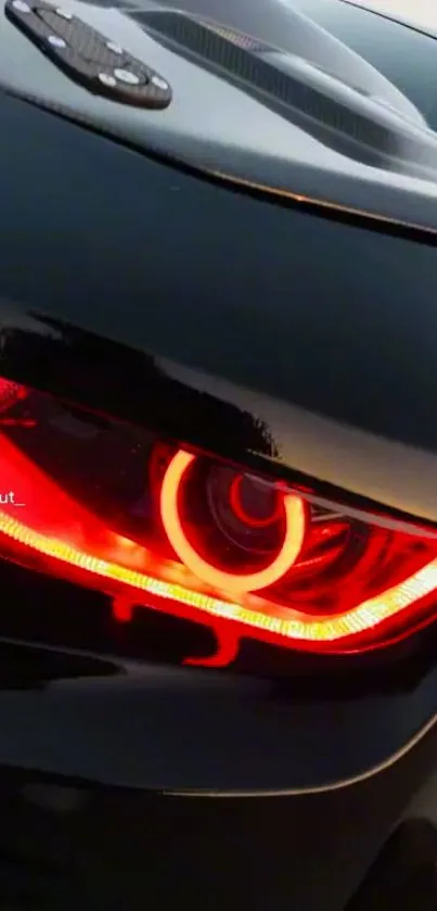 A sleek car's red eye glowing intensely against a dark background.