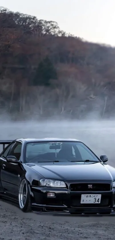 Black sports car in a misty forest landscape.