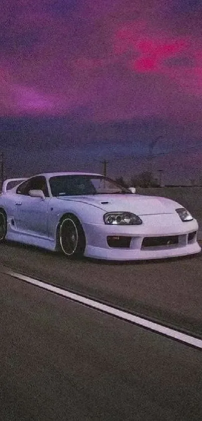 White sports car driving under a vibrant pink and purple sunset sky.