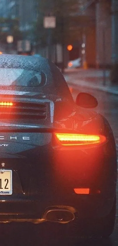 A sleek car with glowing taillights on a rainy city street at night.