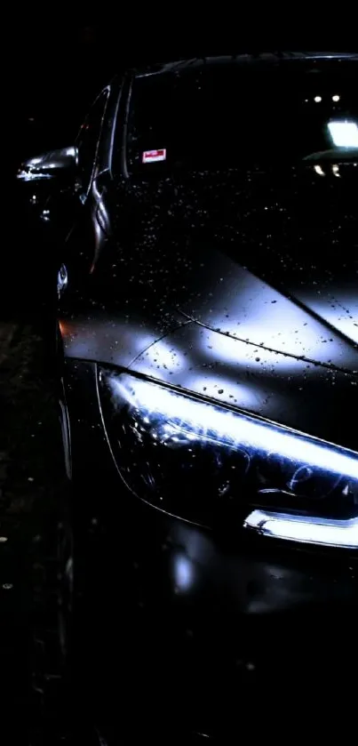 Sleek black car in rain with illuminated headlight at night.