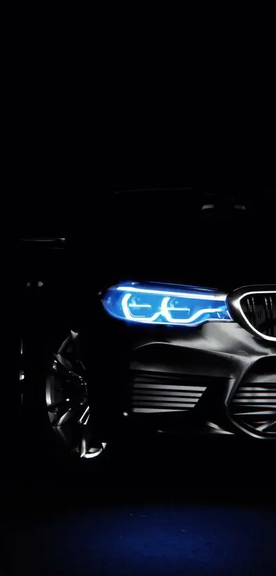 Sleek car with illuminated headlight against dark night background.