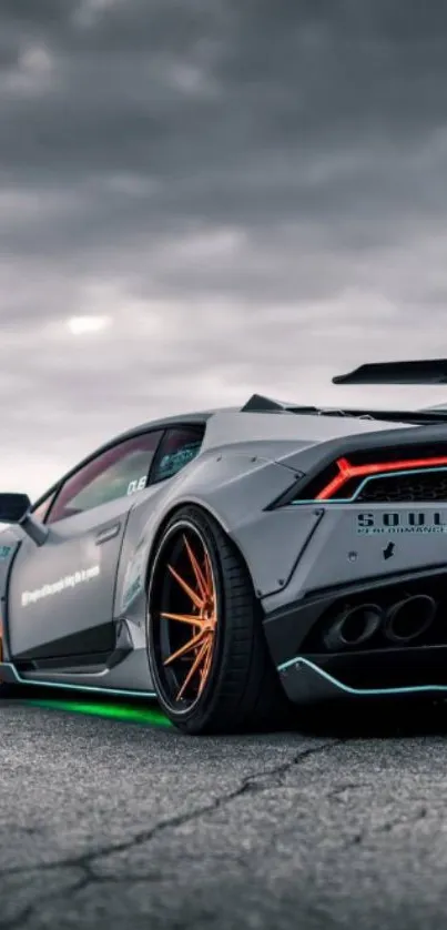 Sleek sports car on open road with a gray cloudy sky.