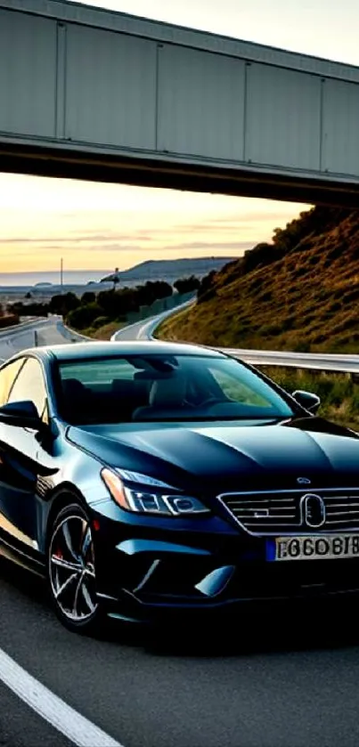 Sleek car driving on a scenic highway at sunset with a bridge overhead.