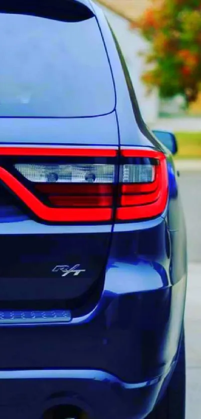 Rear view of a dark blue SUV with red taillights on a street.