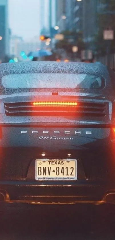 Rear view of a sleek car on wet city street at night.