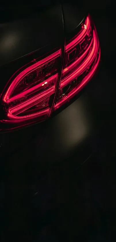 Car taillight glowing red in the dark, sleek and stylish design.