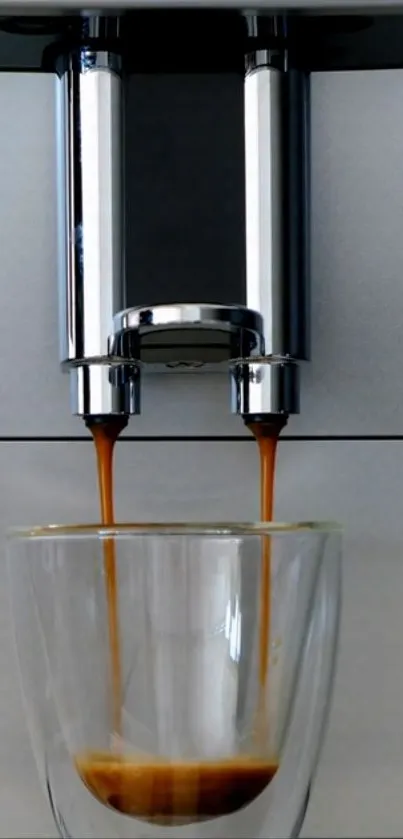 Minimalist coffee maker with glass capturing espresso shot.