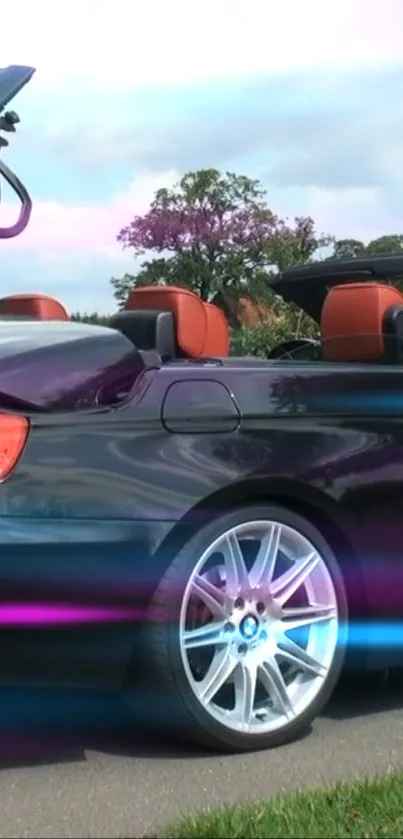 Sleek convertible car with open top and shiny rims against a scenic sky.