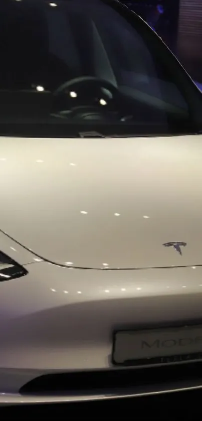 Sleek white Tesla car in showroom lighting.