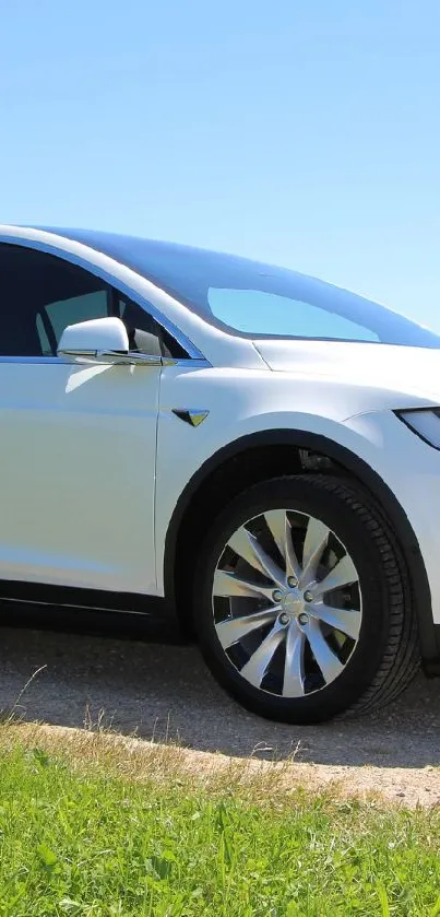 Modern electric car on a scenic route under a blue sky.