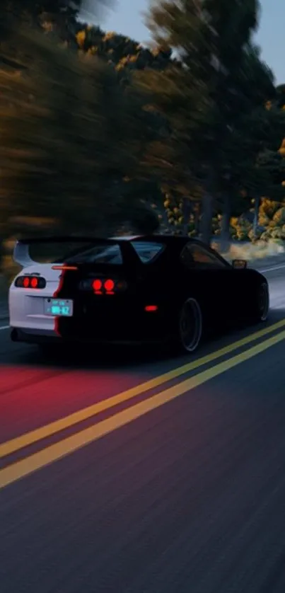 Sleek car speeding on a winding mountain road at night.