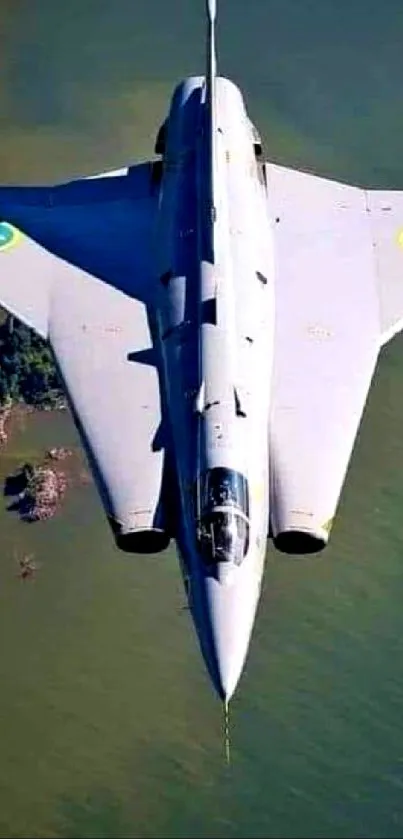 Sleek fighter jet flying over water in a clear sky.