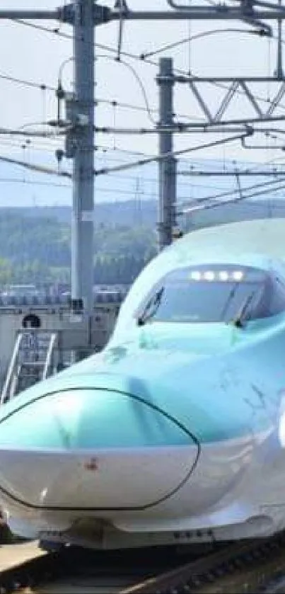 Sleek blue high-speed train on railway tracks under clear skies.