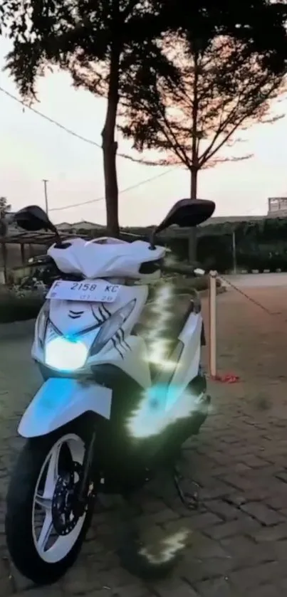 Stylish motorcycle parked at sunset with glowing headlights.