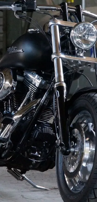 Sleek black motorcycle parked in an industrial garage setting.