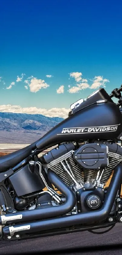 Motorcycle on a desert road with a bright blue sky and mountains.