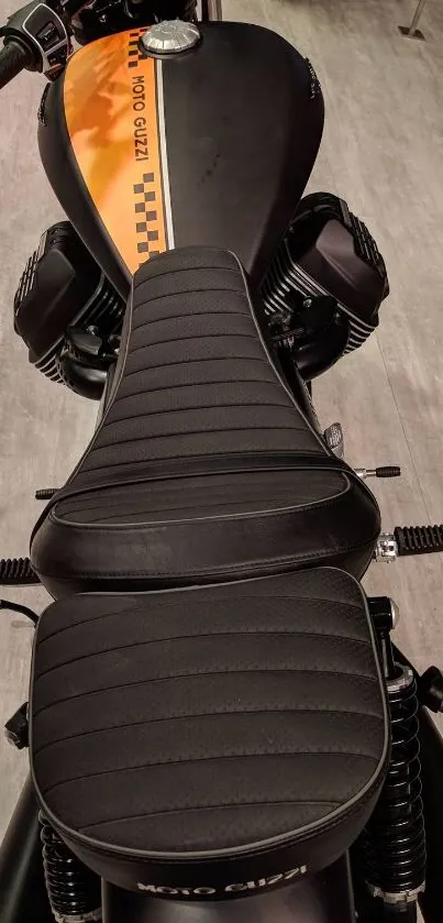 Sleek black motorcycle seat with orange stripe.