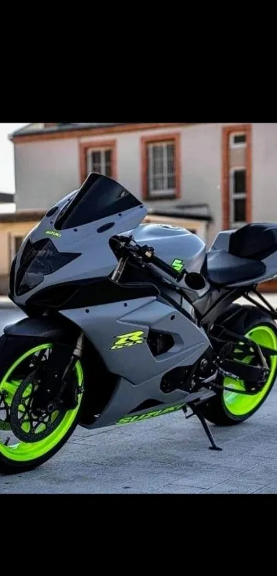 Sleek gray motorcycle with neon wheels on street background.