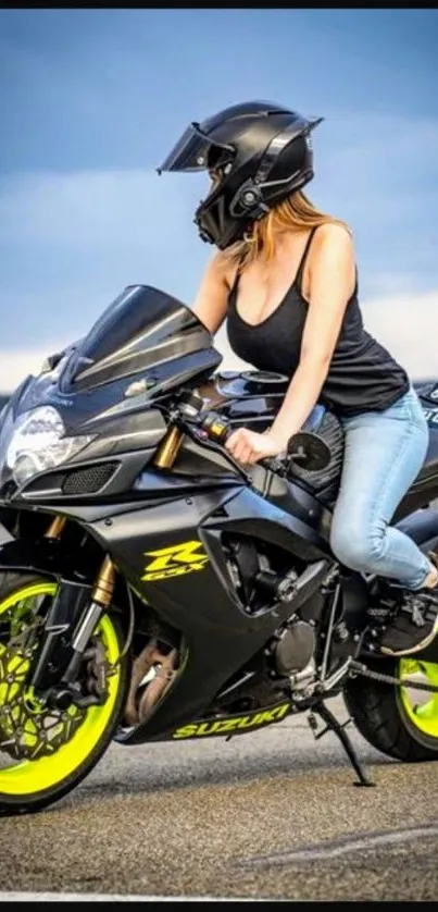 Woman on black motorcycle with neon wheels on a road.