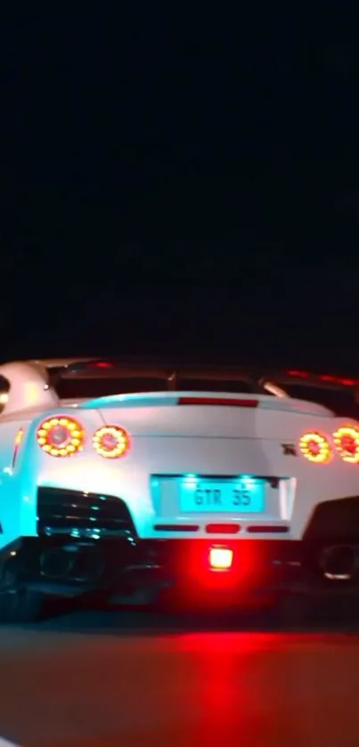 Sleek sports car with red lights driving at night.