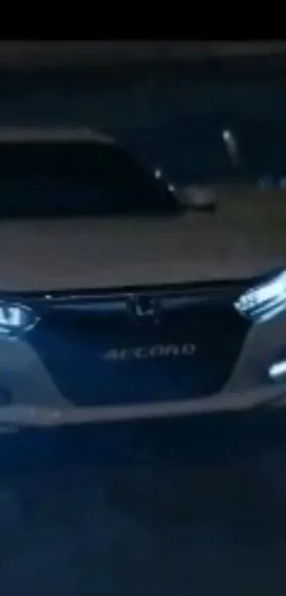 Sleek car driving at night with glowing headlights.