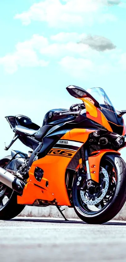 Orange sports motorcycle on open road background.