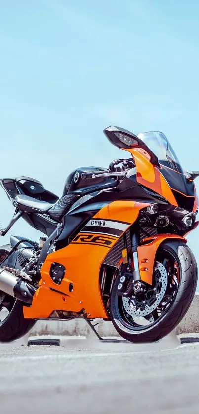 Orange motorcycle with a sleek design under a clear sky.