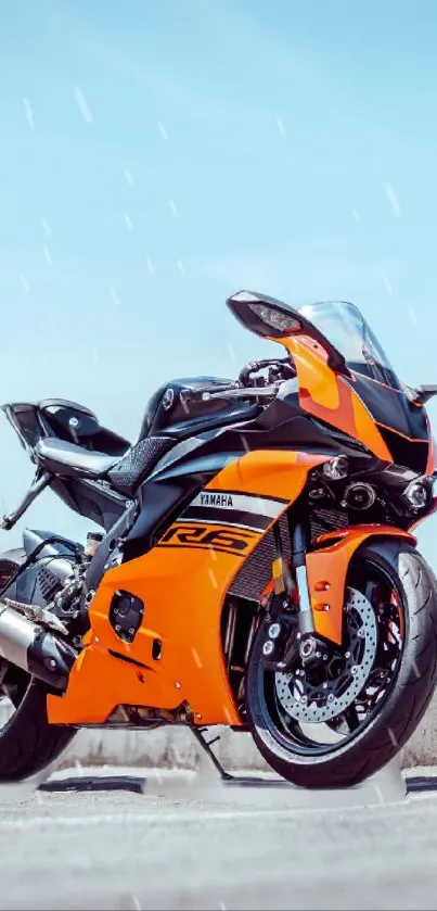 Orange sports motorcycle against blue sky.