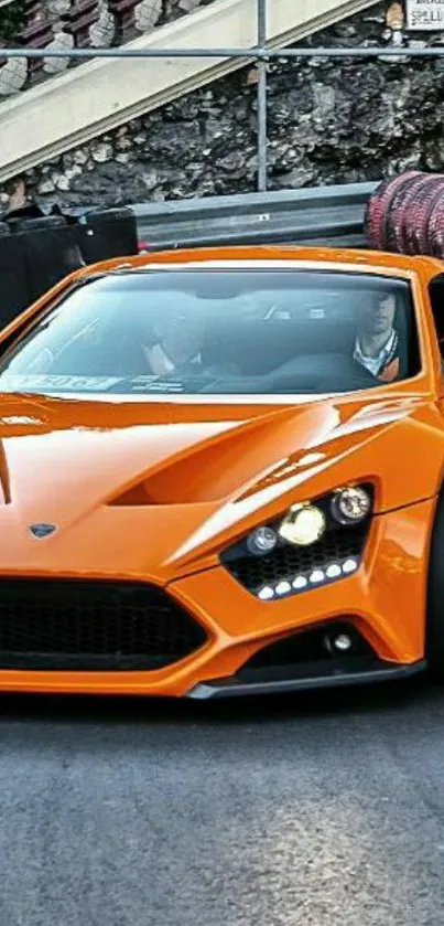 Orange sports car on a racetrack, showcasing luxury.