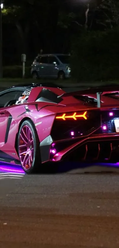 Sleek pink sports car parked at night.
