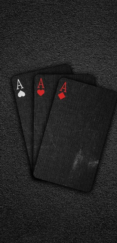 Black playing cards with red accents on a textured dark background.