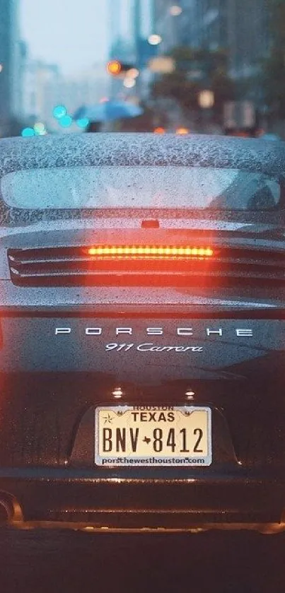 Sleek car on rainy city street at night.