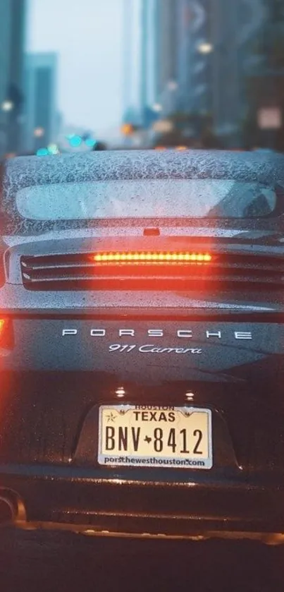 Porsche on a rainy street with city lights in the background.