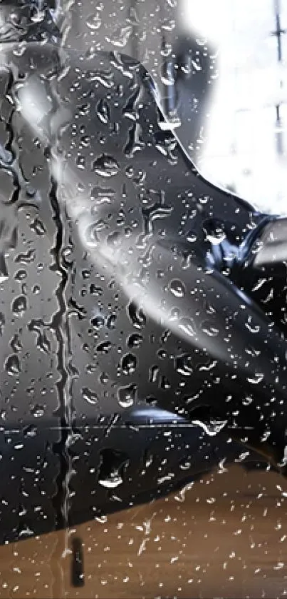 Sleek black car seen through raindrop-covered glass, creating a moody aesthetic.