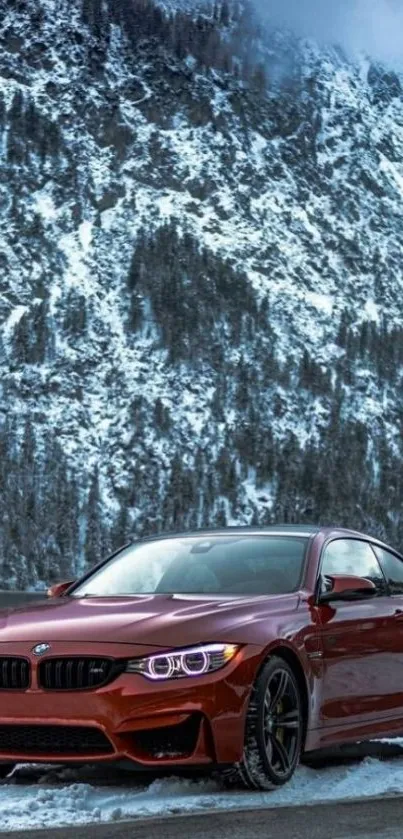 Red sports car parked in front of snowy mountain landscape.