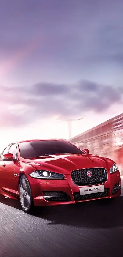 Sleek red car driving against a blurred urban background.